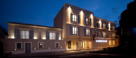 A multi-story hotel with illuminated balconies and a sign reading "IA PASTIDE DU FORN".