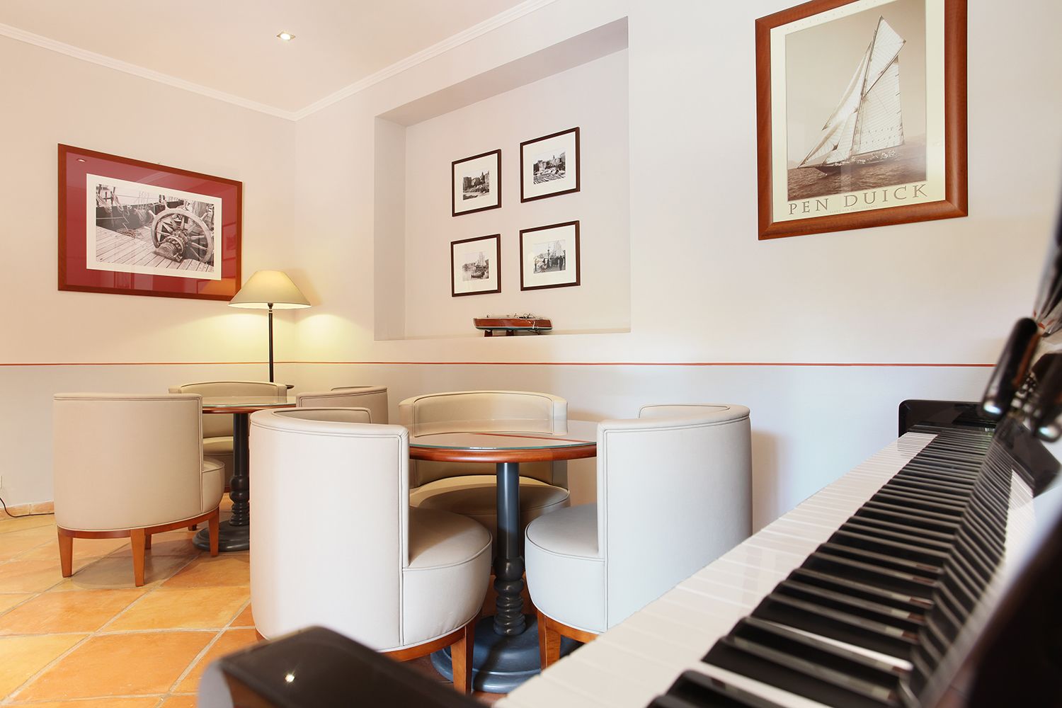 Ein Essbereich mit einem Klavier, vier gerahmten Bildern an der Wand und einem Tisch mit vier Stühlen.