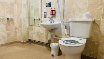 Un baño con inodoro, lavamanos y ducha.