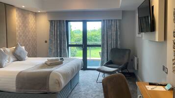 Een hotelkamer met een bed, een stoel, een bureau en een televisie.