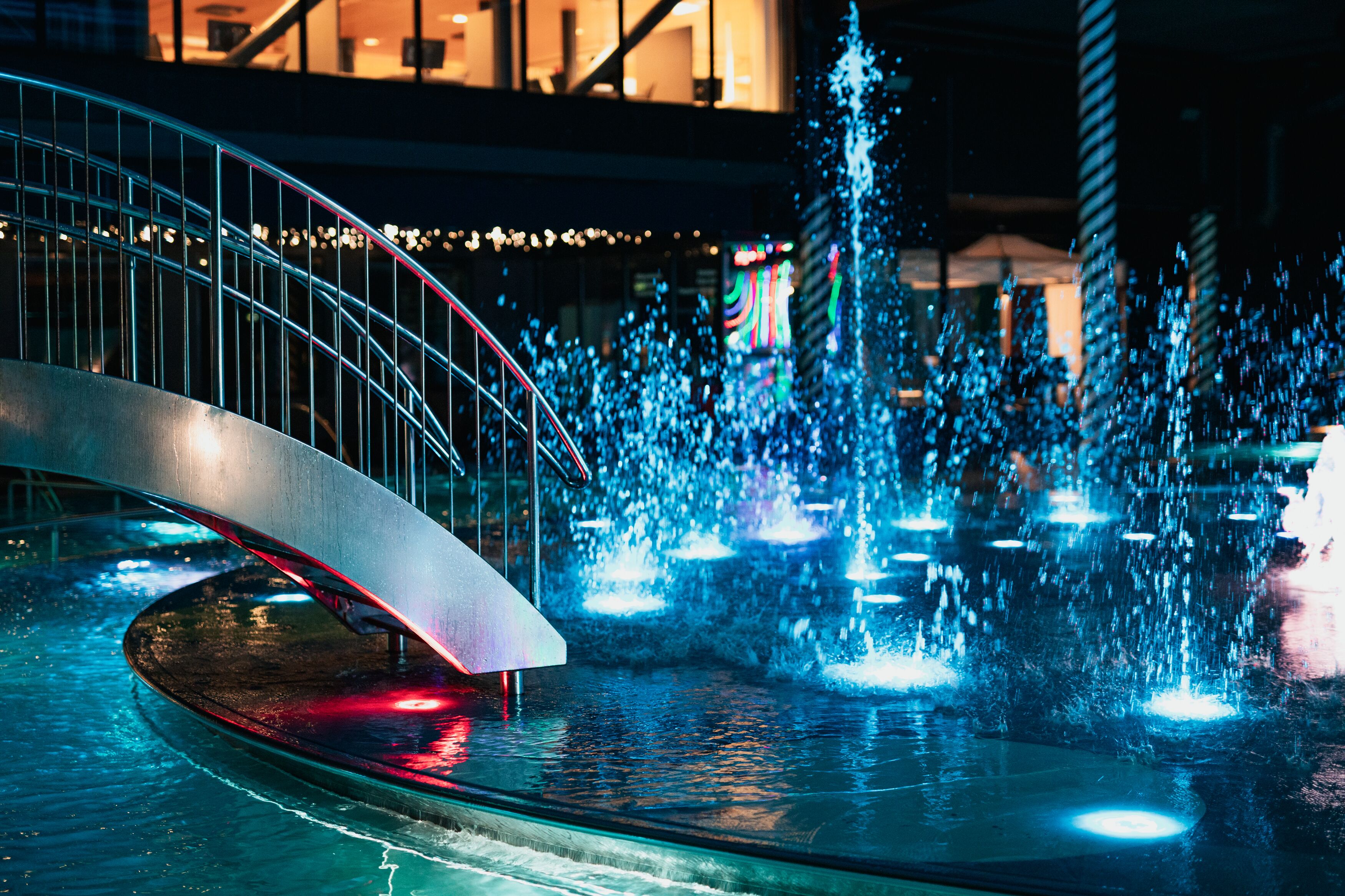 A water fountain with a curved metal structure and multiple jets of water.