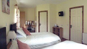 A bedroom with two beds, a desk, a chair, and a radiator. - Deerpark Manor Bed & Breakfast (Swinford)