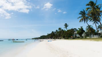Tæt på stranden, hvidt sand, parasoller, badehåndklæder