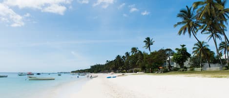 Vlak bij het strand, wit zand, parasols, strandlakens