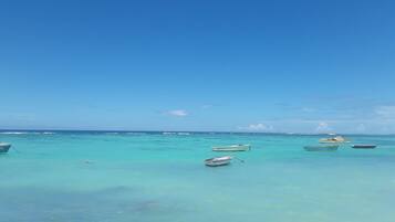 Una playa cerca, arena blanca, sombrillas, toallas de playa