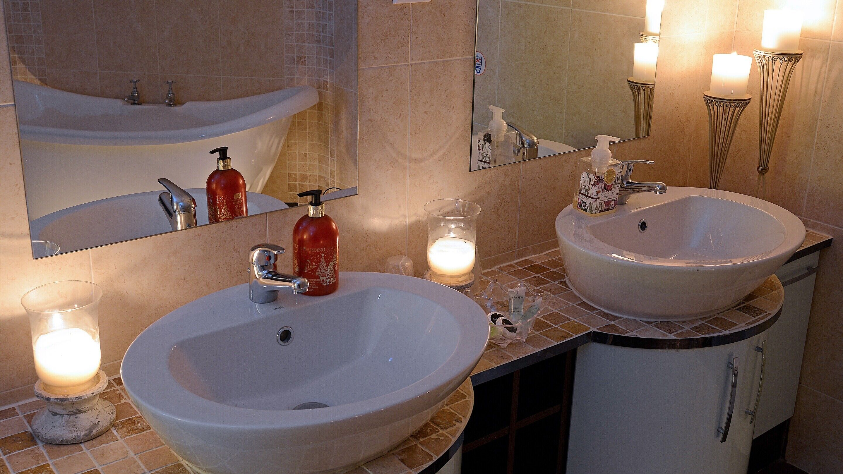 A bathroom with two sinks, a mirror, and a towel rack.