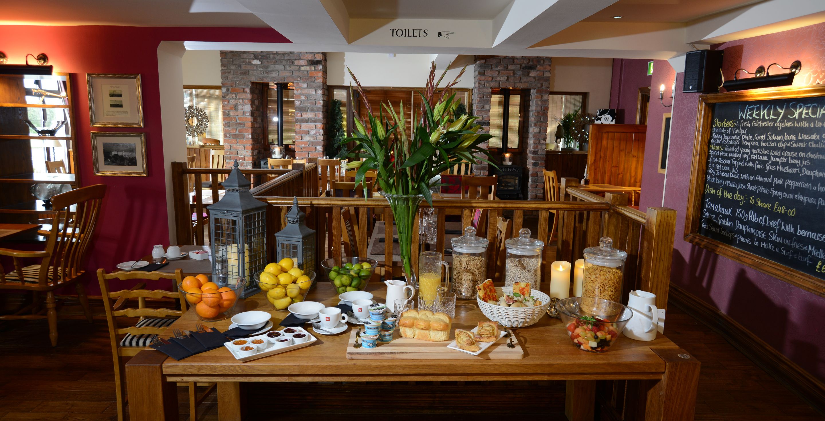 A breakfast buffet setup with various food items and a chalkboard menu in a restaurant.