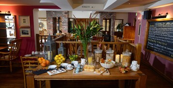A breakfast buffet setup with various food items and a chalkboard menu in a restaurant.