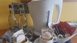 A tray with two cups of Border Biscuits, a coffee maker, and a basket of snacks. - The Birley Arms Hotel (Preston)
