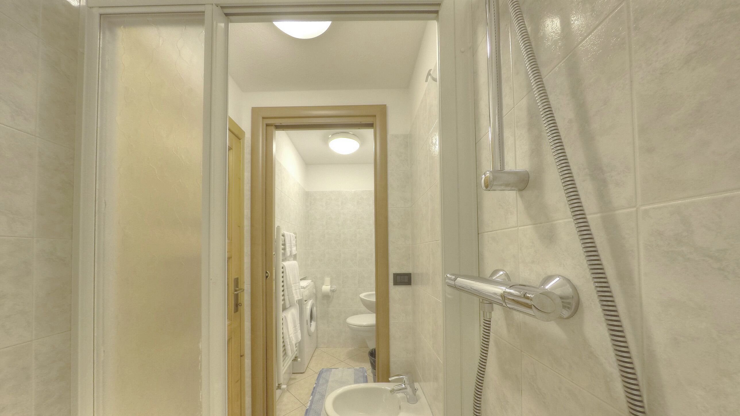 A bathroom with a shower, toilet, and sink.