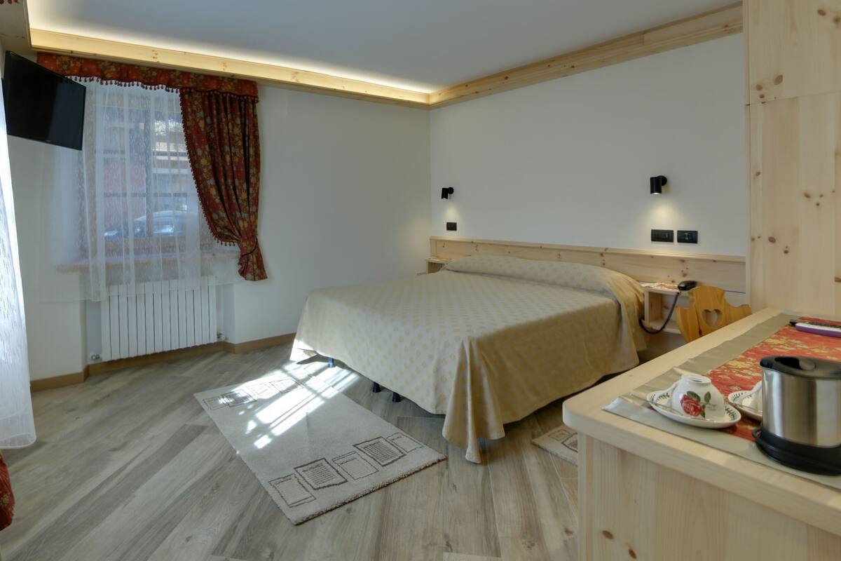 Ein Schlafzimmer mit Bett, Nachttisch und einer kleinen Küchenzeile.