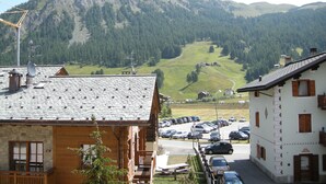 A mountain view with a parking lot and buildings. - Hotel Ristorante Federia (Livigno)