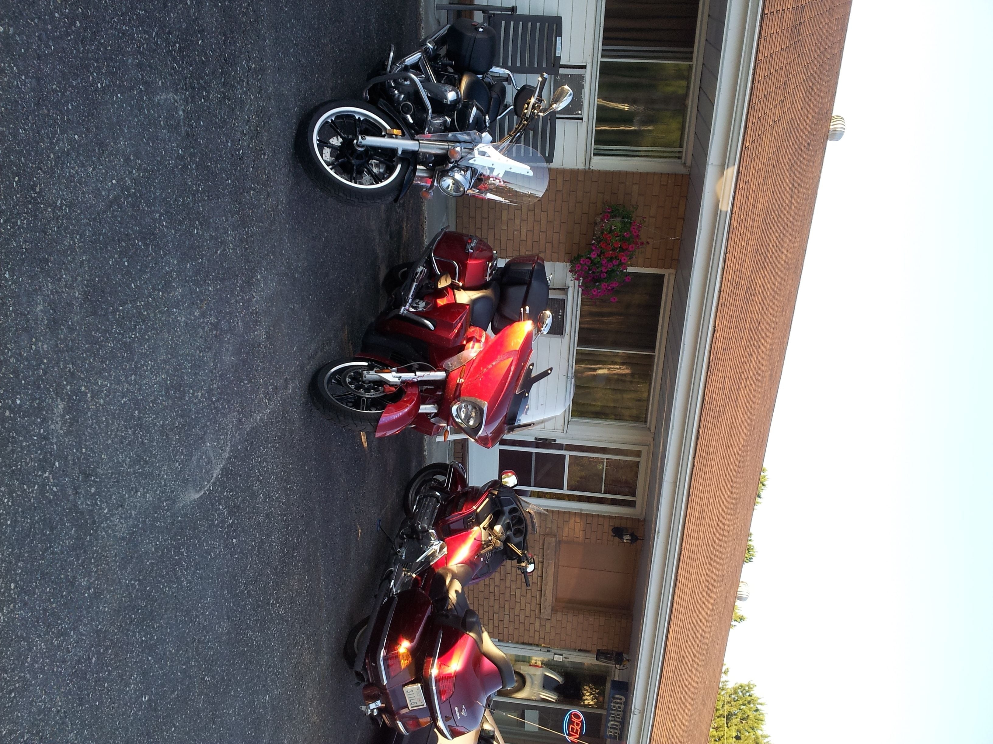 Three motorcycles parked in a driveway.