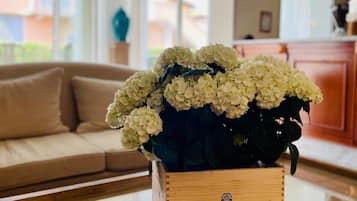 A living room with a wooden coffee table holding a vase of white flowers.