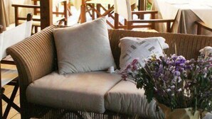 Une table en bois ornée d’un arrangement floral et sur laquelle se trouve une assiette de nourriture.
