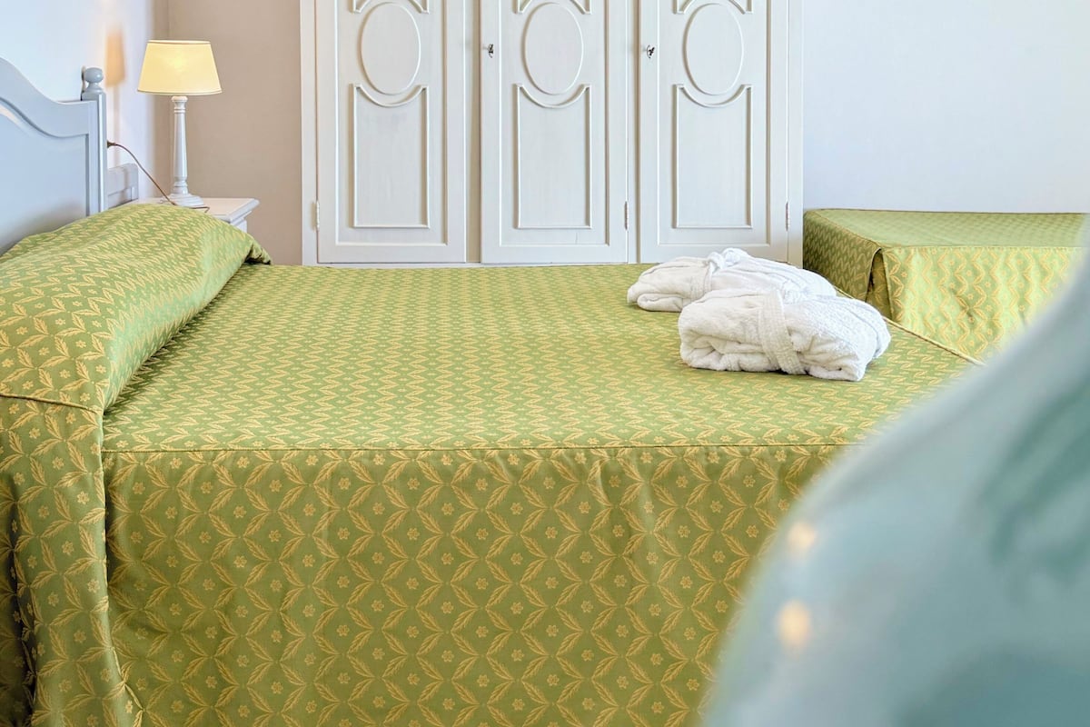 A room with a bed, a lamp, and a wardrobe.