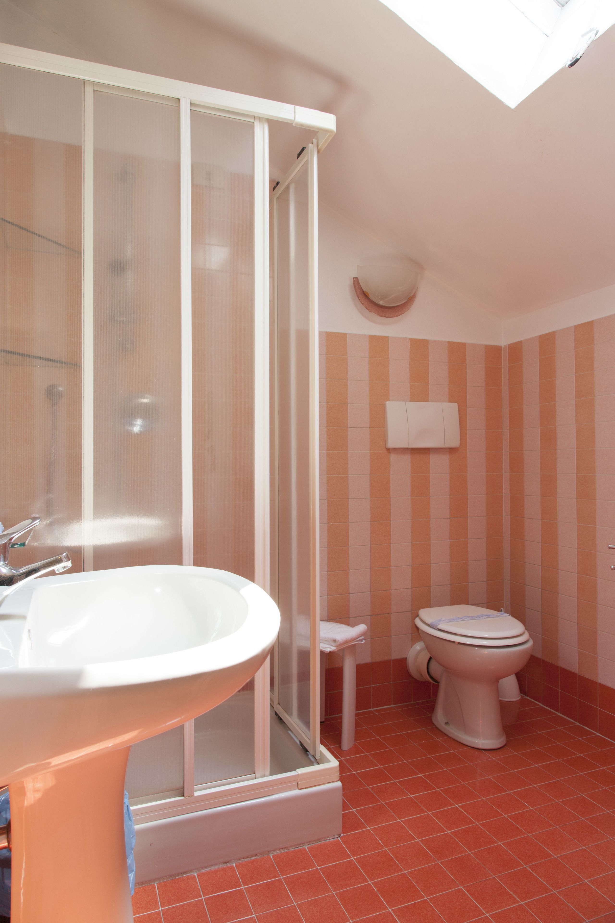 Une salle de bain avec douche, toilettes et lavabo.
