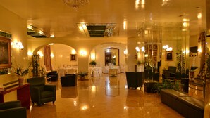 A spacious lobby with a polished marble floor, comfortable seating areas, and a grand chandelier. - Hotel Europa (Rho)