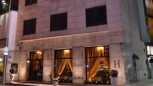 A hotel with a modern facade, multiple windows, and illuminated signage. - Hotel Europa (Rho)
