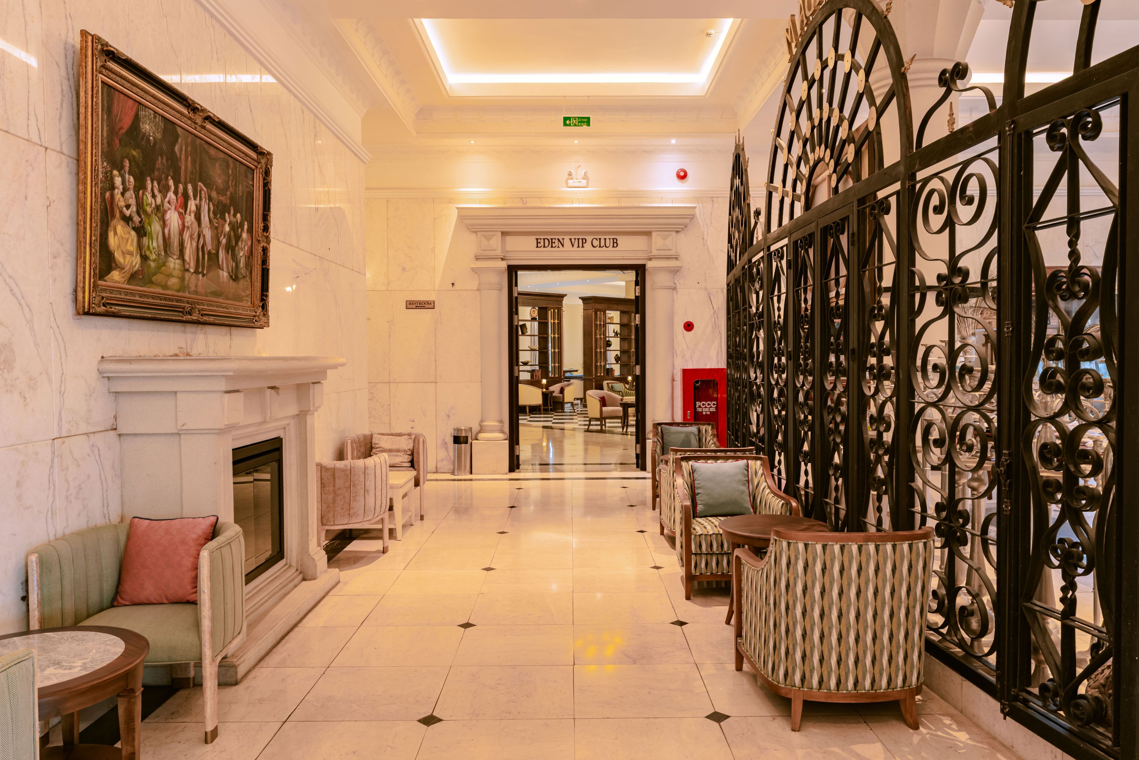 Un vestíbulo de hotel con chimenea, zona de estar y vistas al Eden VIP Club.