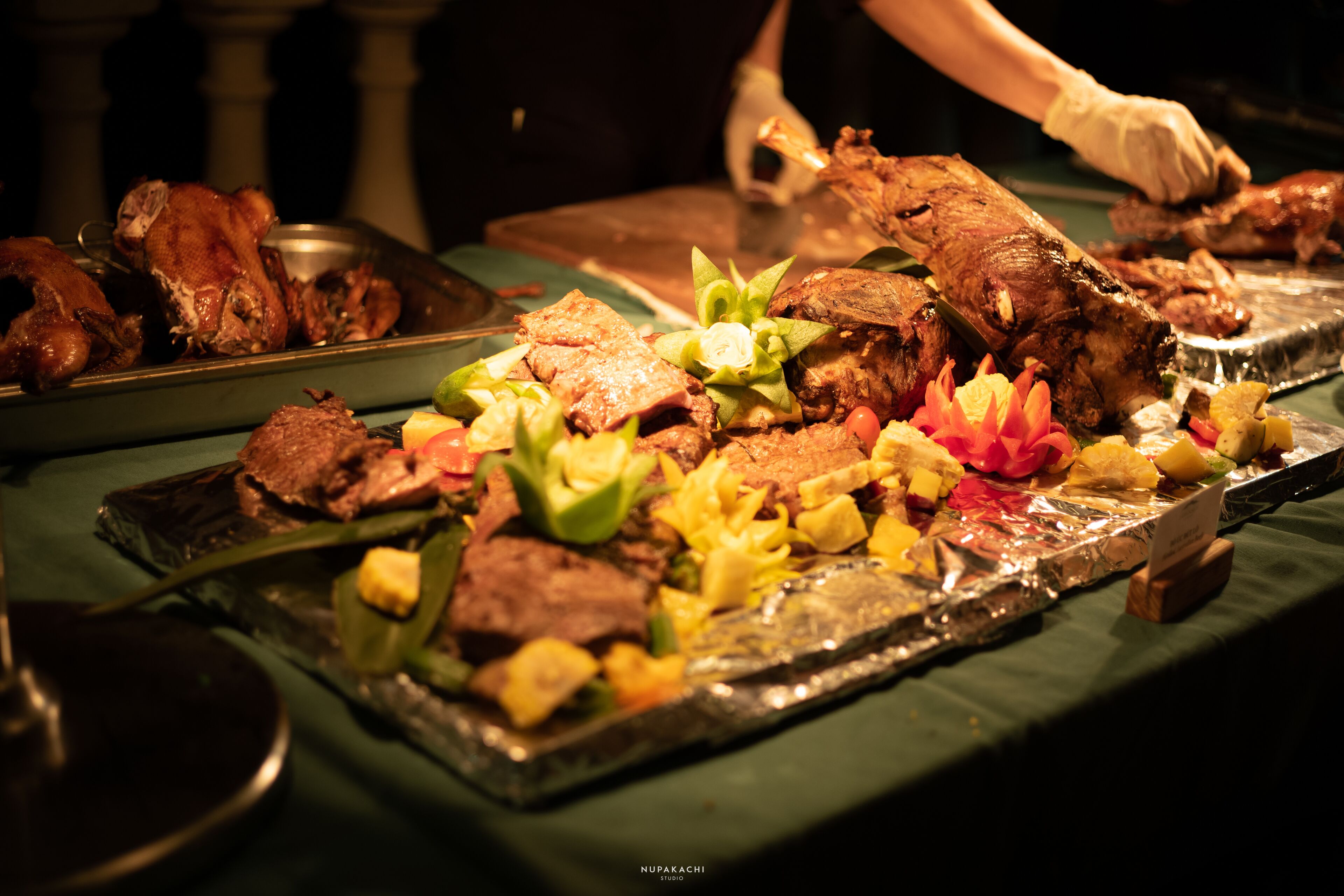 Une table de buffet proposant différentes sortes de viandes et de légumes.