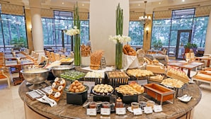 A buffet with various food items and a view of the outdoors. - Dalat Edensee Lake Resort & Spa (Xuan Huong - Da Lat)