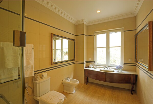 A bathroom with a toilet, bidet, vanity, and large windows. - Dalat Edensee Lake Resort & Spa (Xuan Huong - Da Lat)
