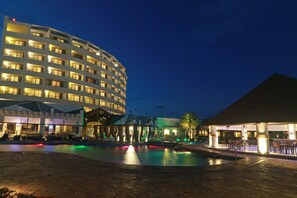 A hotel with a pool area, outdoor seating, and a large building with multiple floors and balconies. - Holiday Inn Tuxpan - Convention Center by IHG (Tuxpan)