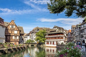 A riverside town with traditional half-timbered houses, a bridge, and a calm waterway. - Holiday Inn Express Strasbourg - Sud by IHG (Geispolsheim)