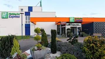 Welcome to the Holiday Inn Express, featuring a modern design with a flat roof and a combination of white and blue accents.