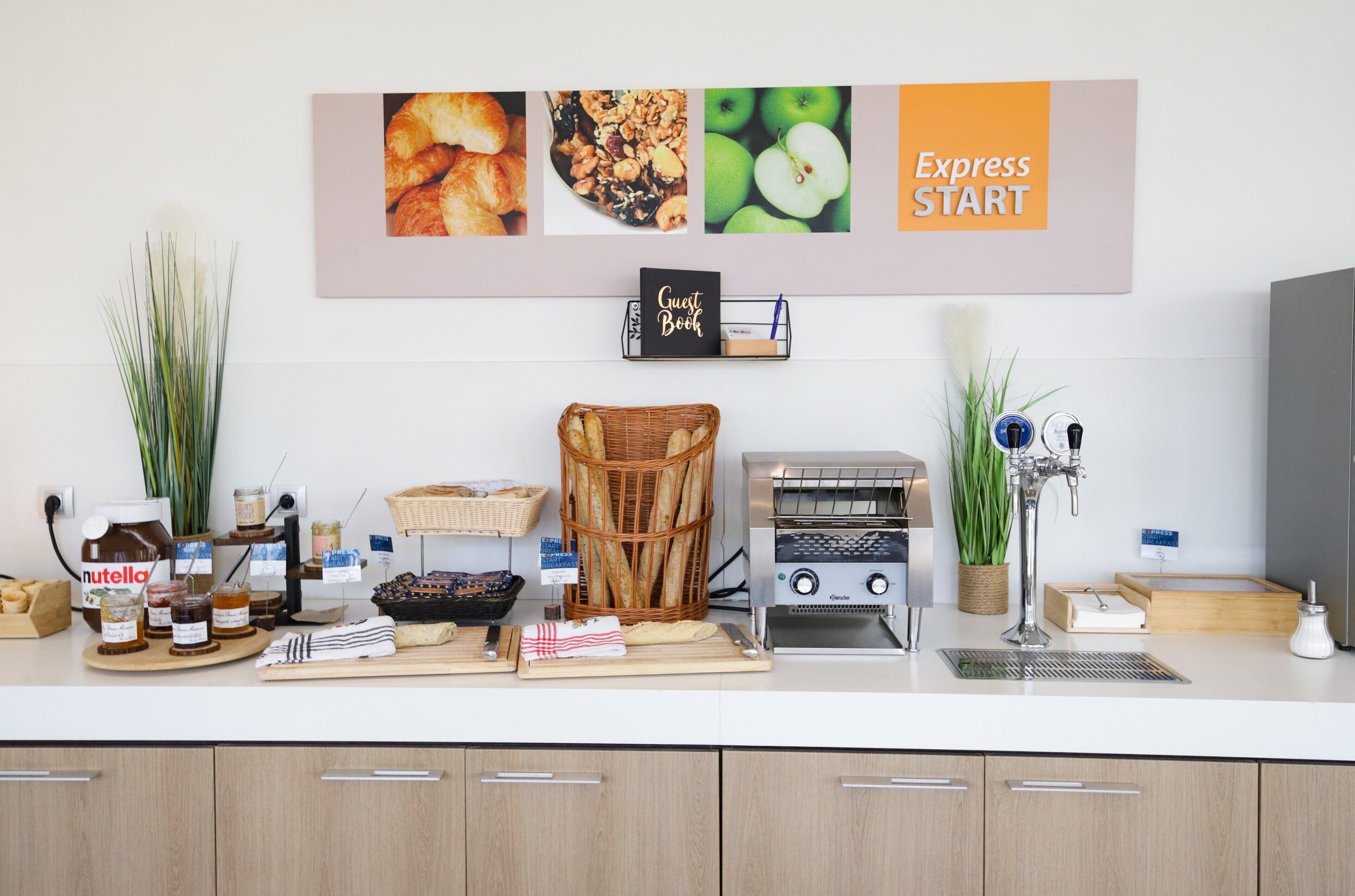 Una encimera de cocina con diversos alimentos, un cesto de pan, un tostador y un letrero que dice "Express Start".