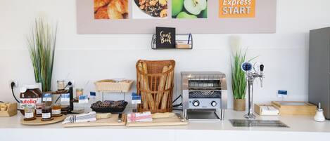 Una encimera de cocina con diversos alimentos, un cesto de pan, un tostador y un letrero que dice "Express Start".