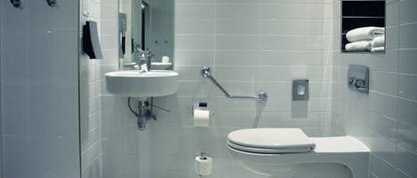 A modern bathroom with a sink, toilet, and shower.
