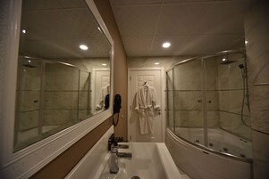Un baño con un espejo grande, una bañera y una ducha.