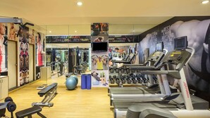 Uma academia com esteiras, máquinas de peso e bolas de exercício.