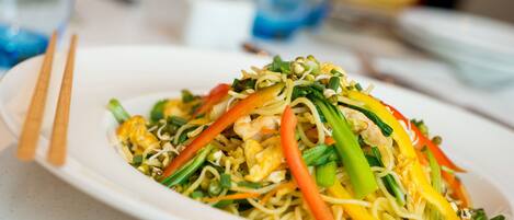A plate of stir-fried noodles with vegetables and shrimp.