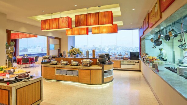Cozinha moderna com serviço de buffet, grandes janelas e vista para a cidade.