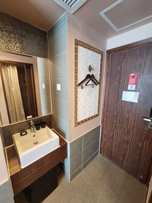 Une salle de bain équipée d’un lavabo, d’un miroir et d’un porte-serviettes.