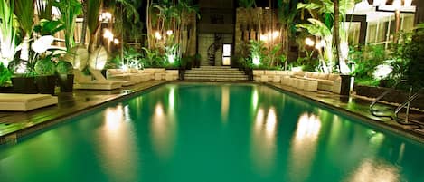 Una piscina al aire libre, sombrillas