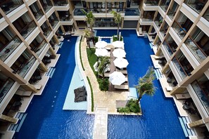 A multi-level hotel with a central swimming pool, outdoor seating areas, and balconies. - Henann Lagoon Resort (Boracay Island)
