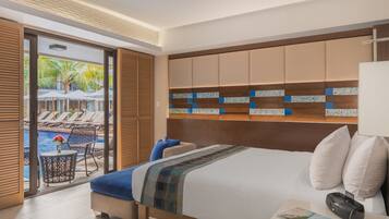 Quarto de hotel com uma cama grande, mesa de cabeceira, abajur e vista para área da piscina com espreguiçadeiras e guarda-sóis.