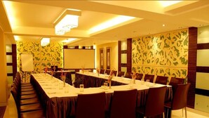 A conference room with a long table, chairs, and a projector screen. - Southern Plaza (Kolkata)