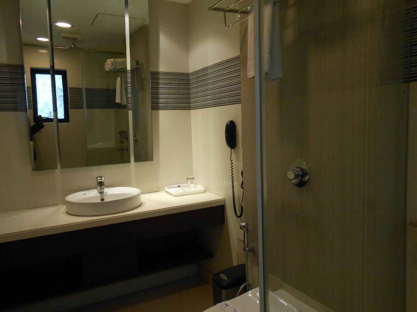 Un baño con lavabo, espejo y teléfono.