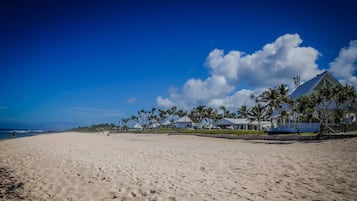 On the beach, white sand, sun loungers, beach umbrellas
