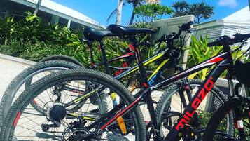 Una bicicletta parcheggiata all'aperto, con cielo sereno e vegetazione sullo sfondo.