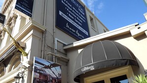 Fasaden på The Glenferrie Hotel pryds av en stor skylt som visar att det finns en uteservering med plats för många gäster, en klassisk arkitektonisk utformning och ett tydligt hotellskylt.