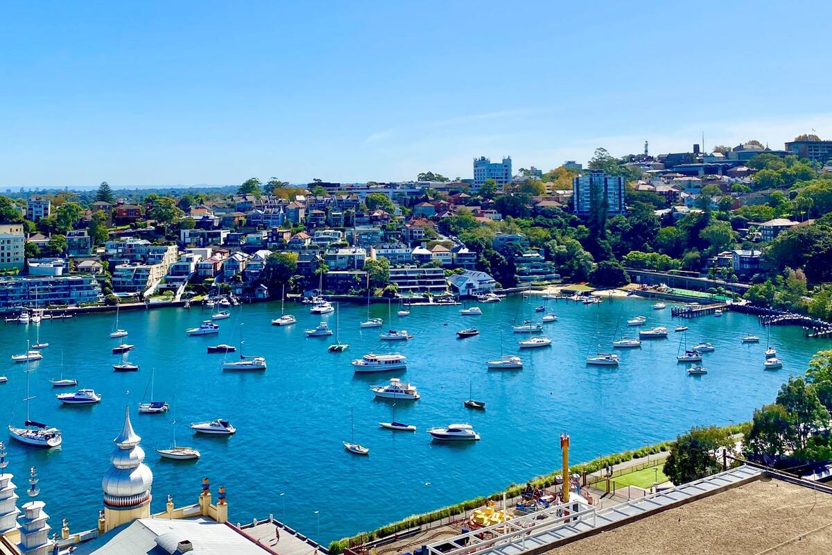 A marina with numerous boats docked, surrounded by residential buildings and greenery.