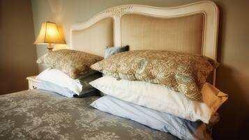 A bed with a patterned bedspread and two decorative pillows.