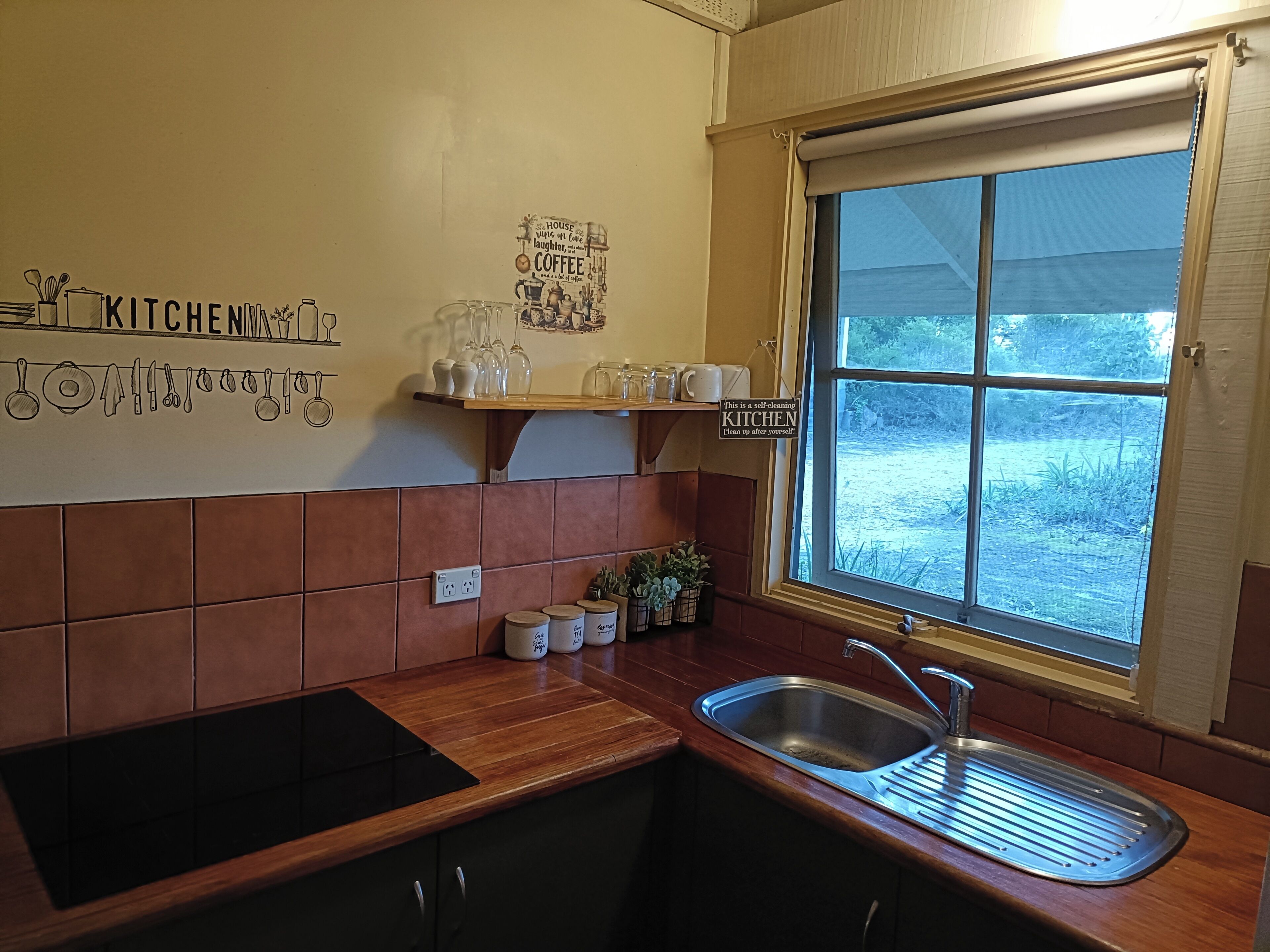 Una cocina con ventana, un lavamanos y una encimera.