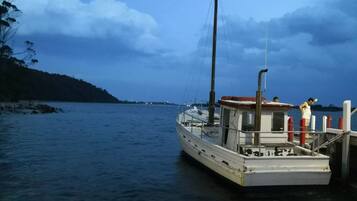 Un bateau était amarré à un quai, et une personne se tenait sur le pont.